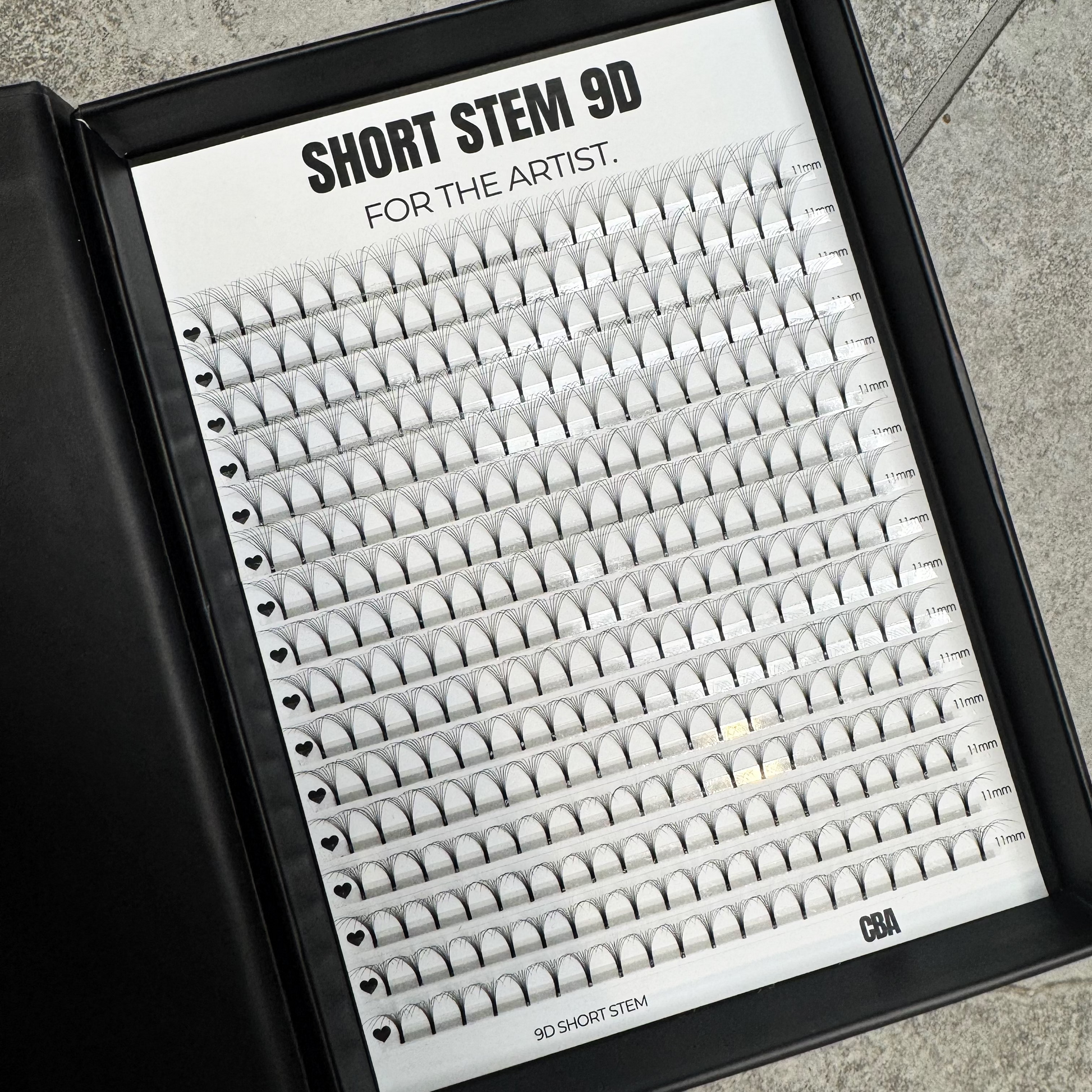 Eyelash extension tray labeled 'Short Stem 9D' on a gray surface