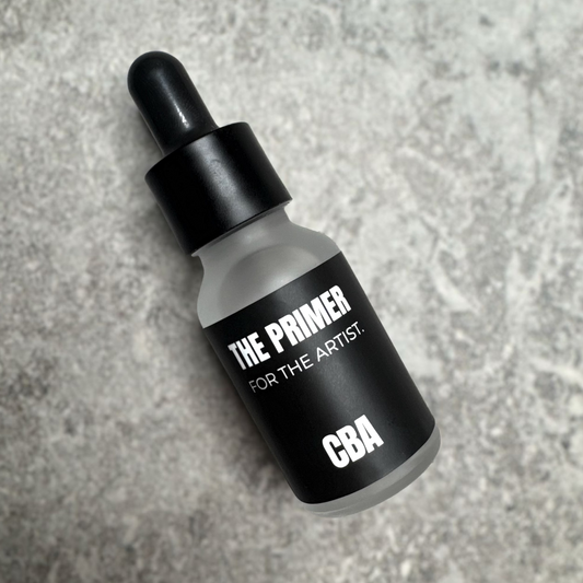 Bottle labeled 'The Primer for the Artist CBA' on a textured gray background