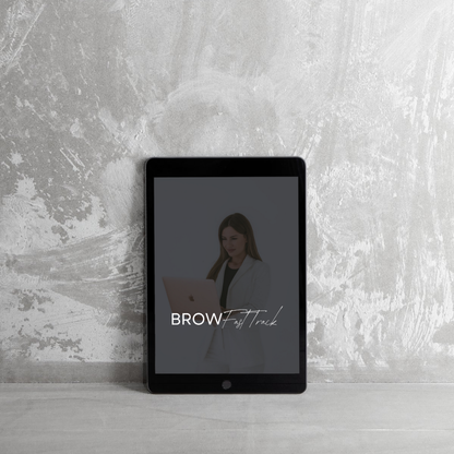 A tablet leans against a textured gray wall, displaying an image of a woman in white holding a laptop. The words BROW Fast Track appear in white text across the screen.